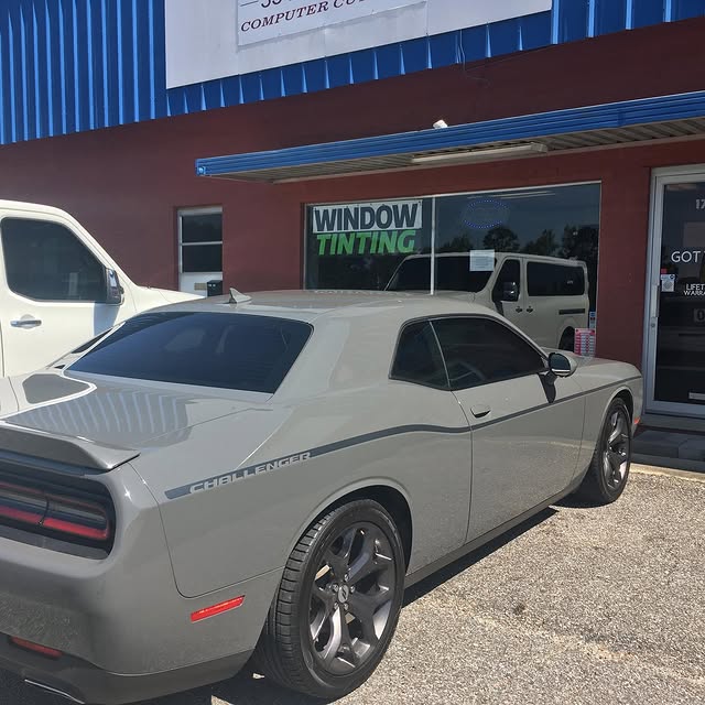 Artint Film installer carefully applying window tint film to a car window
